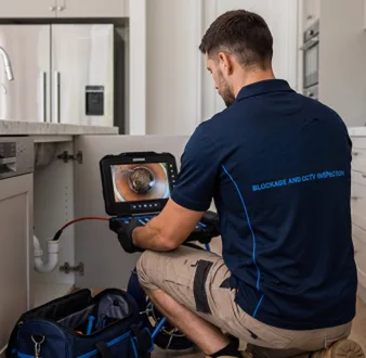 Plumber clearing a blocked toilet in a Strathfield South bathroom